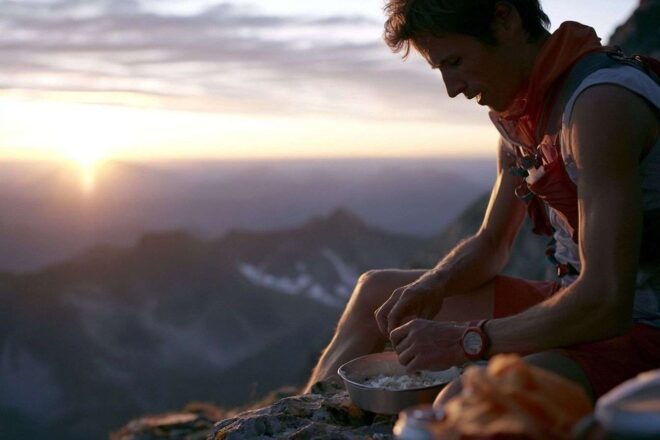 Trail runner prêt pour un petit déjeuner énergétique devant une montagne à l aube